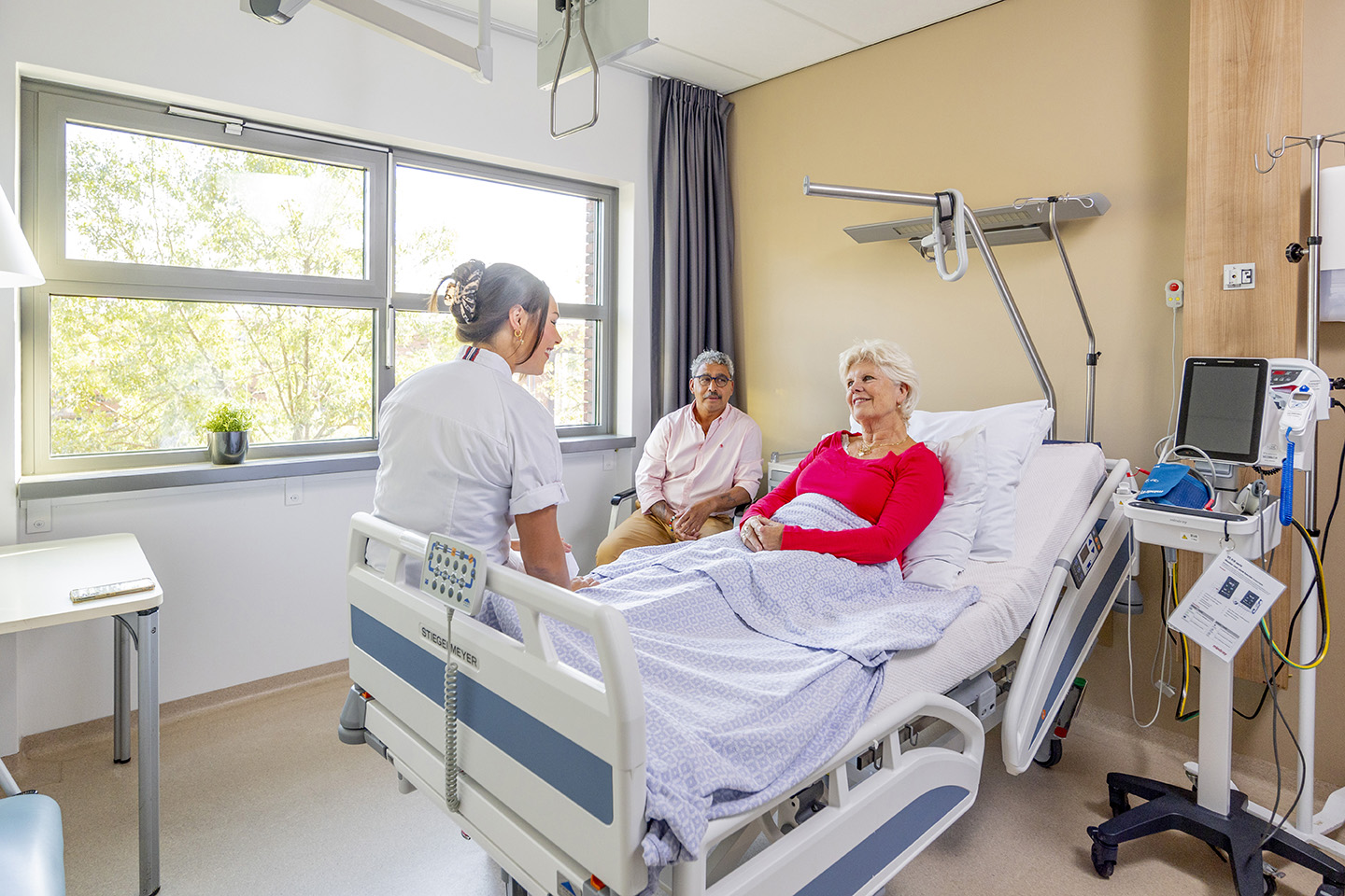 Verpleegkundige aan bed bij patient